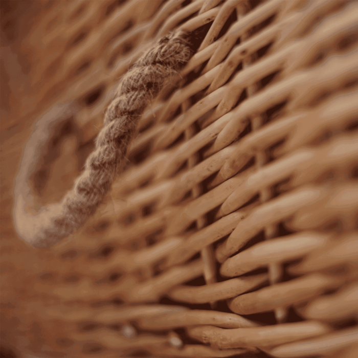 Detail van het vlechtwerk van de wilgentenen uitvaartmand, toont ambacht en natuurlijke textuur.