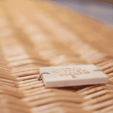 Wilgentenen uitvaartmand in een natuurlijke omgeving, symboliseert harmonie en duurzaamheid.