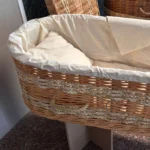 Handgevlochten uitvaartmand van duurzaam wilgenteen en maïsblad in warme aardetinten