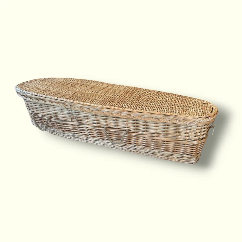 Handgevlochten uitvaartmand voor kinderen van natuurlijke wilgentenen, met matrasje, kussen en lakentje voor een zacht afscheid.